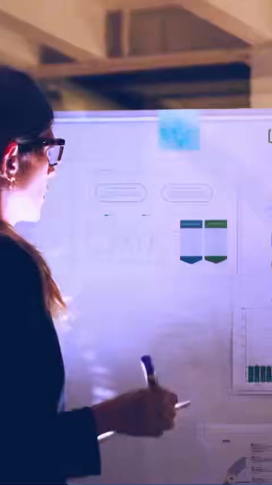 Colleagues reviewing charts on a whiteboard, then scenes from a control room, warehouse, hospital and shop