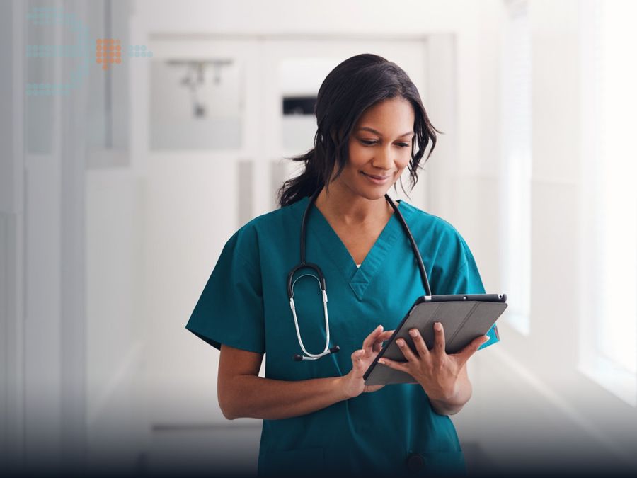 Nurse in scrubs reviewing a tablet