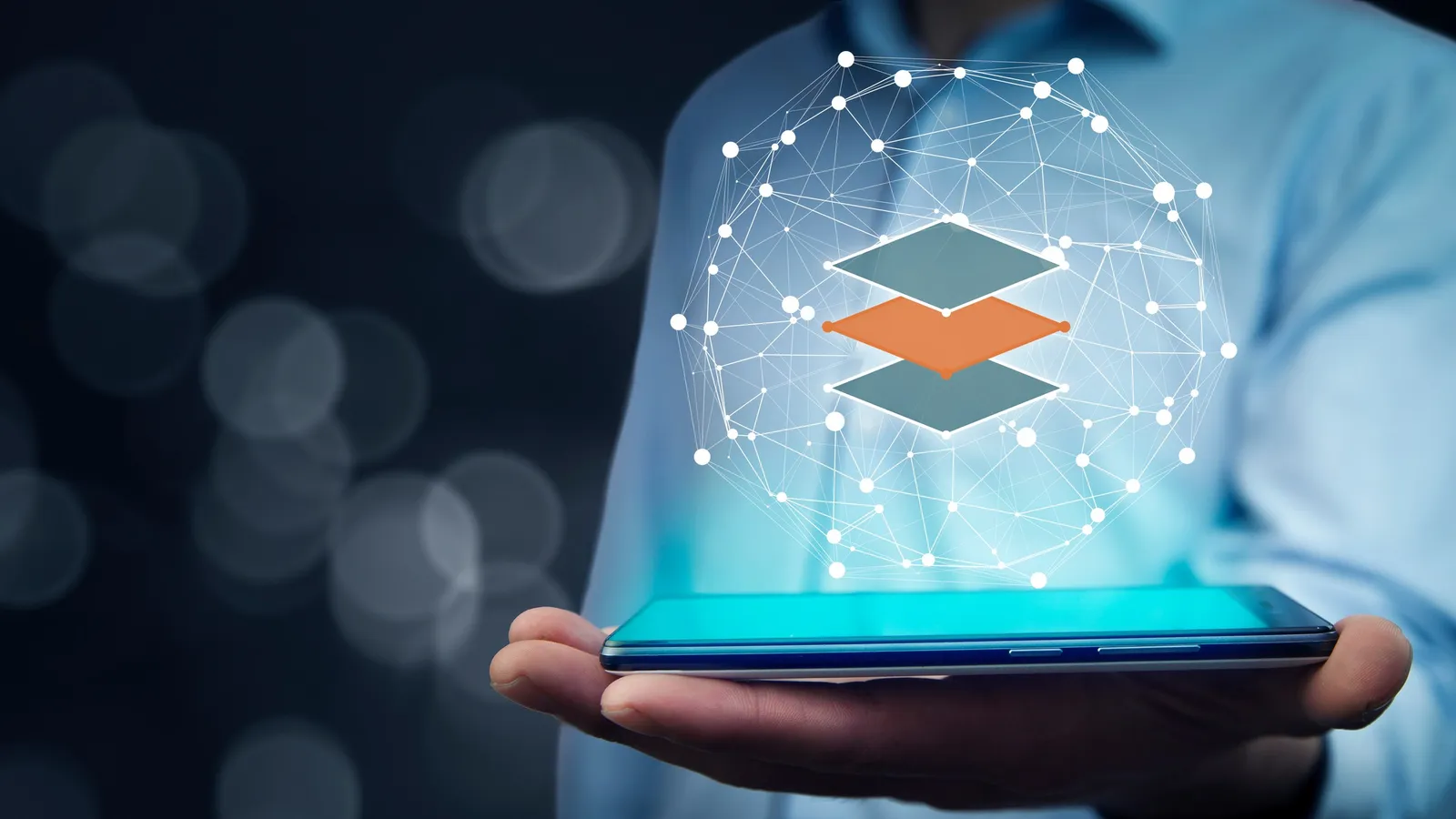 A hand holding a tablet with a glowing network sphere above it, and three stacked layers in the centre with the middle layer in copper